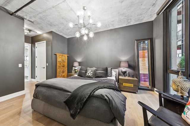 bedroom featuring a notable chandelier and light wood-type flooring