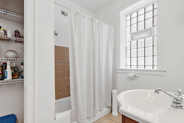 bathroom with tile patterned floors, visible vents, shower / bath combo, and a sink