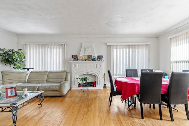 dining area with hardwood / wood-style flooring and a fireplace with raised hearth