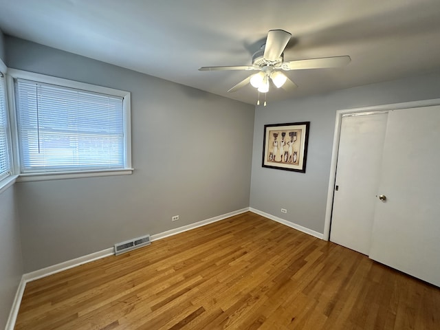 unfurnished bedroom featuring light hardwood / wood-style flooring, a closet, and ceiling fan