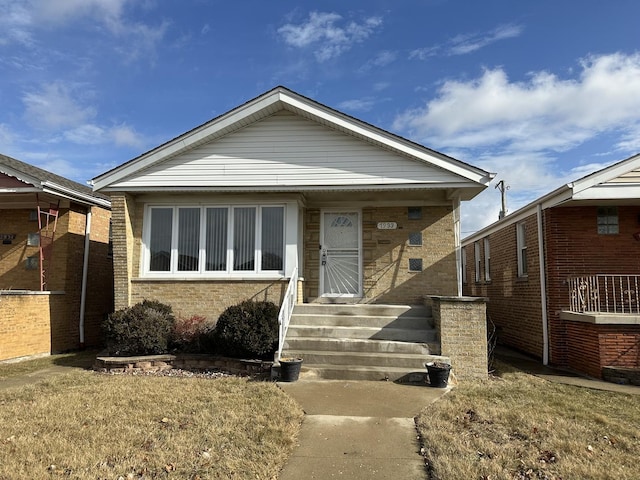 bungalow-style home with a front lawn