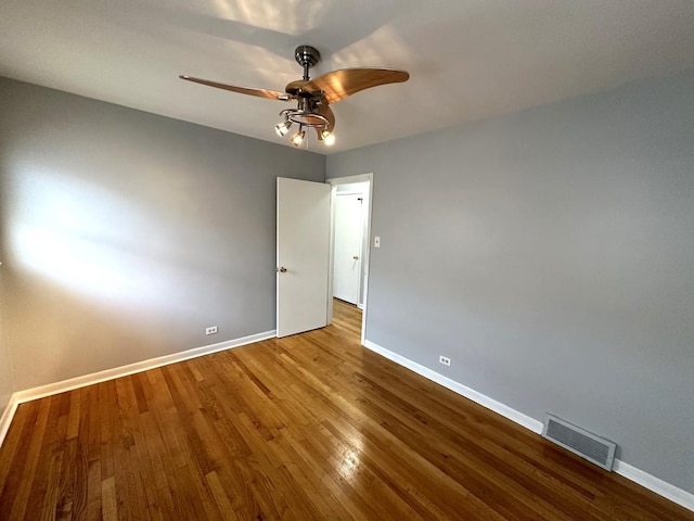 empty room with ceiling fan and hardwood / wood-style floors