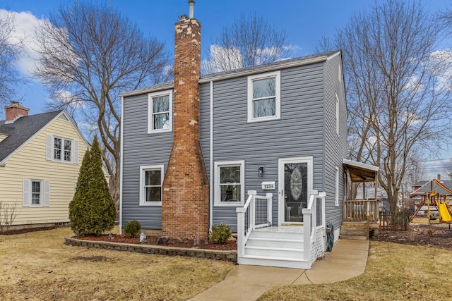 view of front facade featuring a front lawn and a chimney