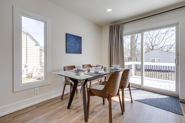dining area featuring light wood-style flooring, baseboards, and a wealth of natural light