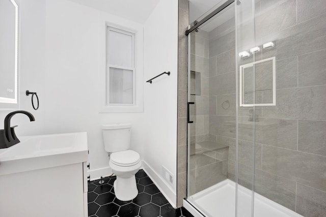 bathroom featuring vanity, tile patterned flooring, toilet, and walk in shower