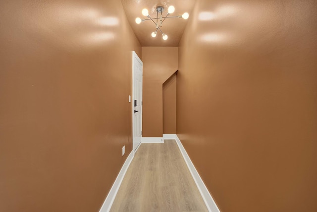 hall with hardwood / wood-style floors and a chandelier