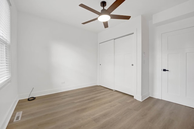 unfurnished bedroom featuring a closet, ceiling fan, and light wood-type flooring