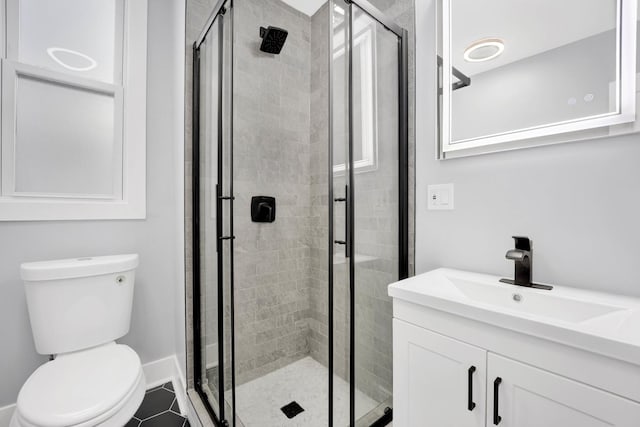 bathroom with an enclosed shower, vanity, tile patterned floors, and toilet