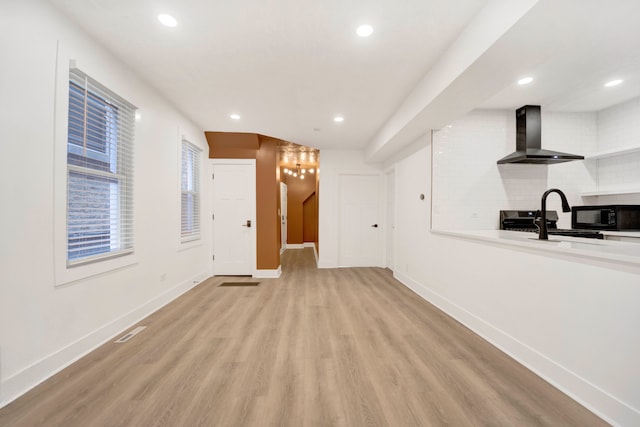 unfurnished living room with sink and light hardwood / wood-style floors