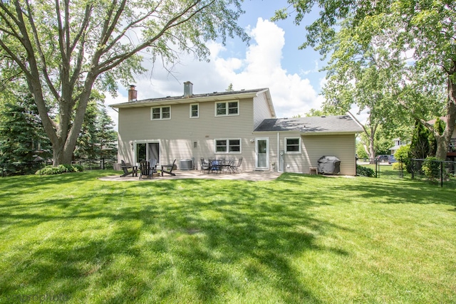 rear view of house with cooling unit, a yard, and a patio