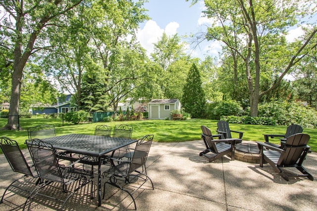 view of patio with a storage shed and an outdoor fire pit