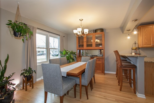 dining space with a chandelier and light hardwood / wood-style floors