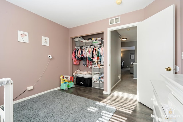 bedroom with dark hardwood / wood-style floors and a closet