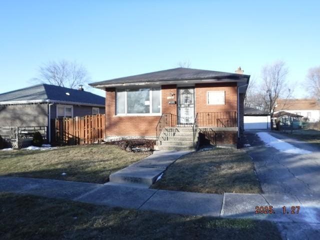 view of front of home featuring a garage, an outbuilding, and a front lawn