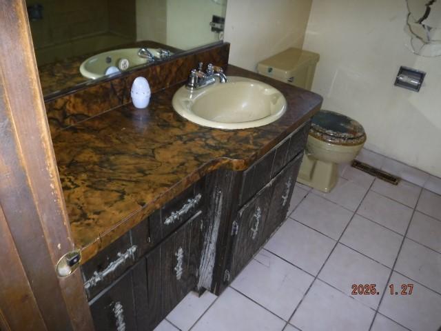 bathroom featuring vanity, tile patterned floors, and toilet