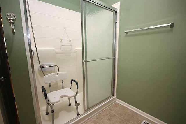 bathroom featuring an enclosed shower and tile patterned floors