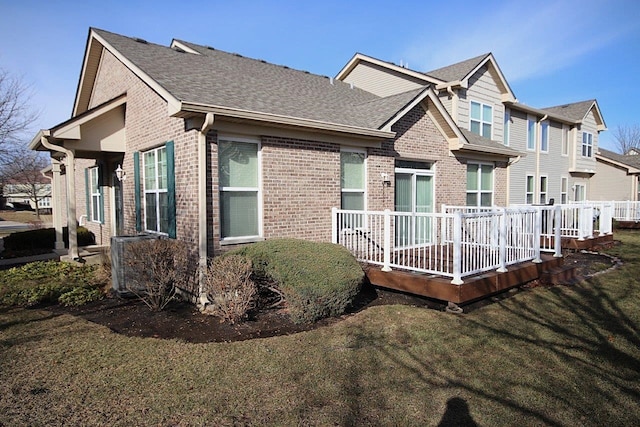 view of front of property featuring a wooden deck and a front lawn