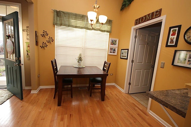 dining space with a chandelier and light hardwood / wood-style flooring