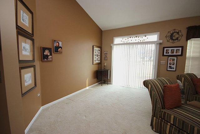 sitting room with lofted ceiling and carpet floors