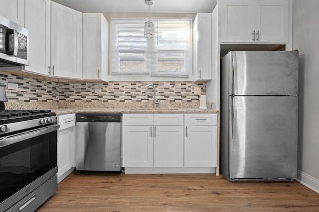 kitchen featuring white cabinetry, sink, hardwood / wood-style floors, and appliances with stainless steel finishes