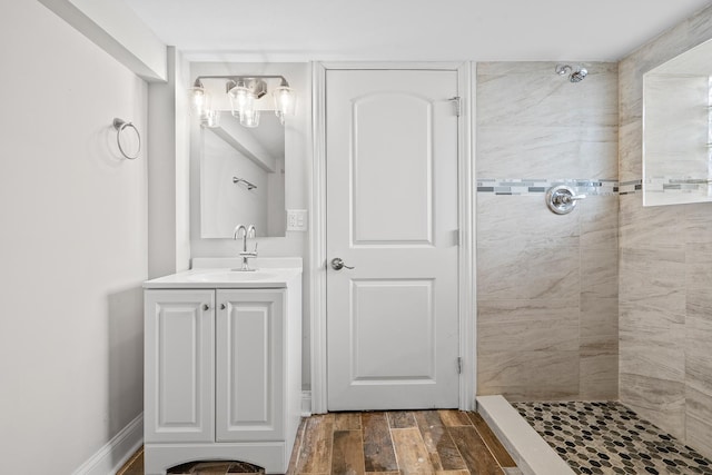bathroom featuring a tile shower, hardwood / wood-style floors, and vanity