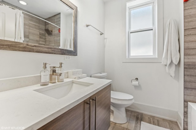 bathroom featuring vanity, hardwood / wood-style floors, curtained shower, and toilet