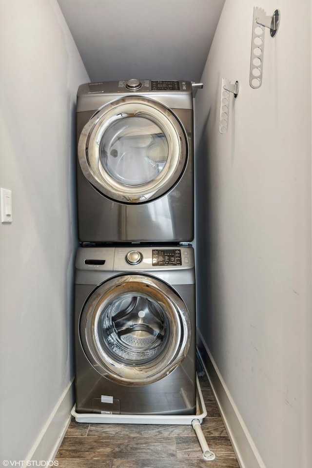 laundry room with stacked washer / dryer and dark hardwood / wood-style floors