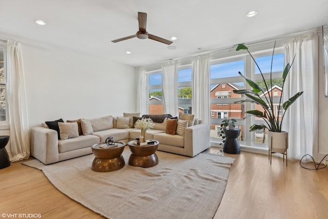 living room featuring wood-type flooring and ceiling fan