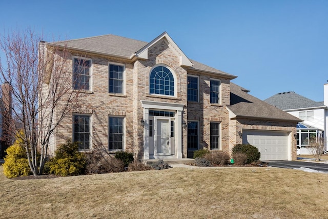 colonial inspired home featuring a garage and a front yard