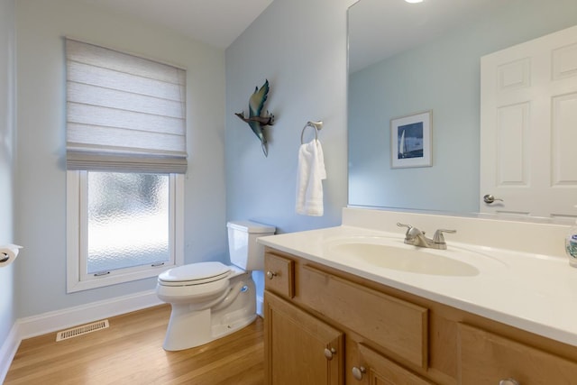 bathroom featuring vanity, toilet, and hardwood / wood-style floors