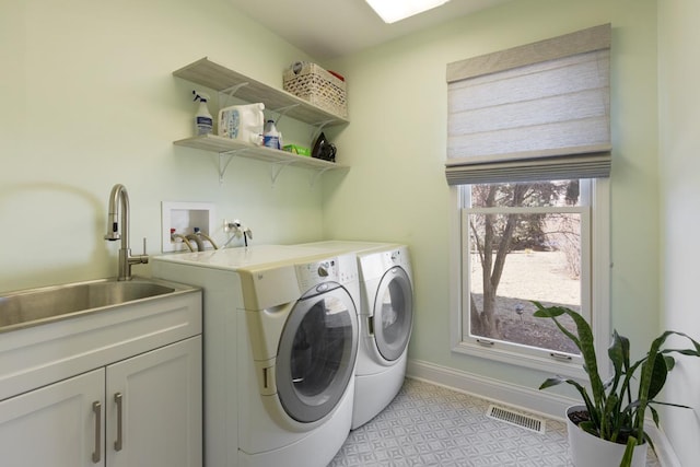 laundry room with washer and dryer, sink, and cabinets