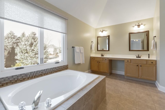 bathroom with vanity, a relaxing tiled tub, vaulted ceiling, and tile patterned floors