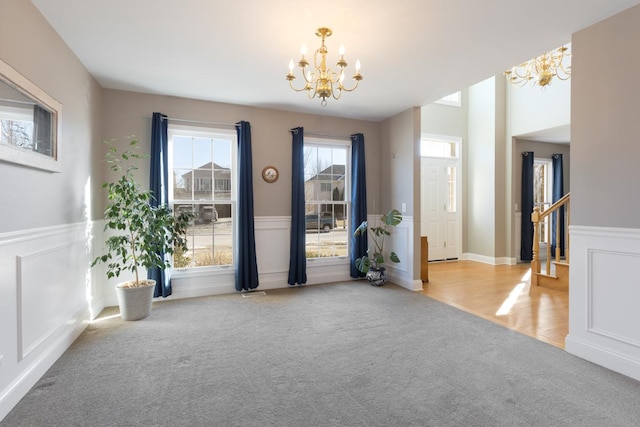 carpeted foyer featuring an inviting chandelier