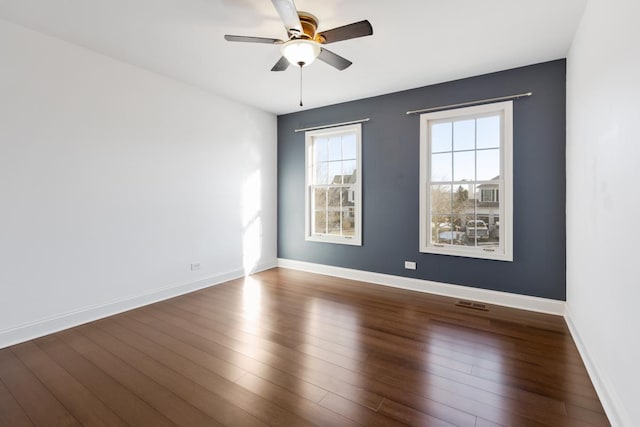 spare room with dark hardwood / wood-style flooring and ceiling fan