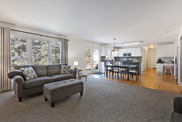 living room with an inviting chandelier and light wood-type flooring