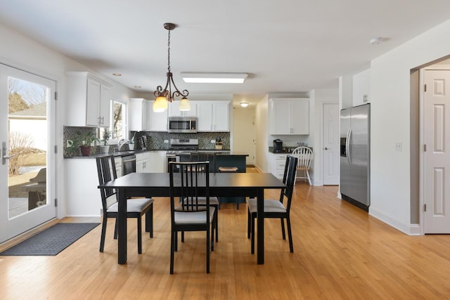 dining room featuring sink, light hardwood / wood-style floors, and a chandelier