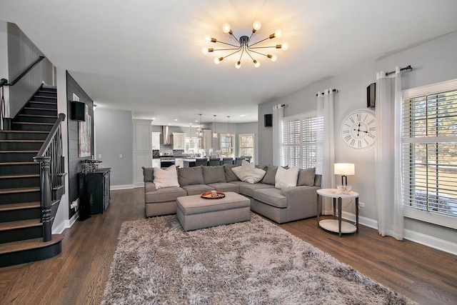 living room with dark hardwood / wood-style floors and an inviting chandelier