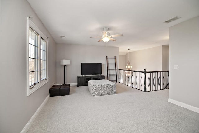 living room with ceiling fan with notable chandelier, carpet floors, and a healthy amount of sunlight