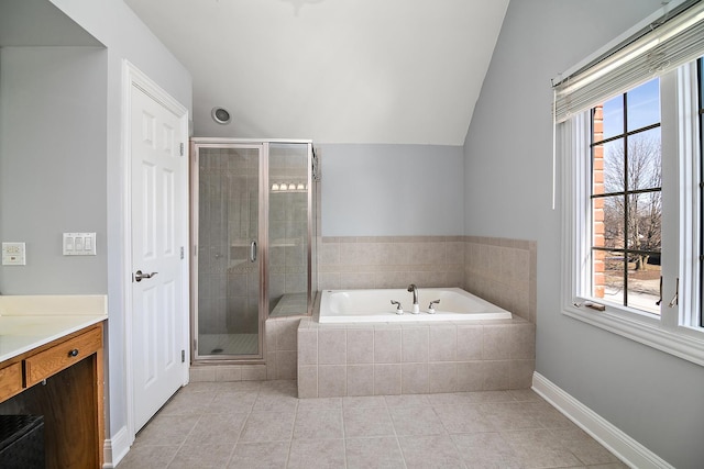 bathroom with tile patterned floors, vaulted ceiling, vanity, and a wealth of natural light