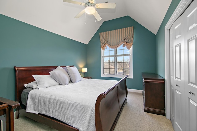 bedroom featuring lofted ceiling, light carpet, a closet, and ceiling fan