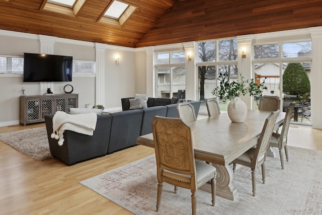 dining room featuring plenty of natural light, lofted ceiling with skylight, and light hardwood / wood-style floors