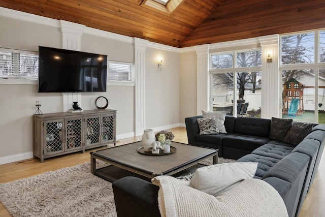 living room featuring plenty of natural light, vaulted ceiling with skylight, and light hardwood / wood-style floors