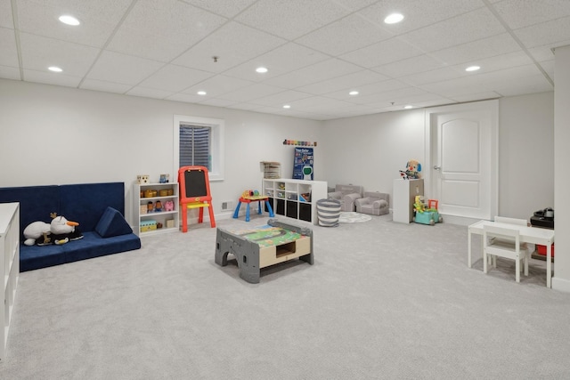 recreation room featuring a drop ceiling and carpet floors