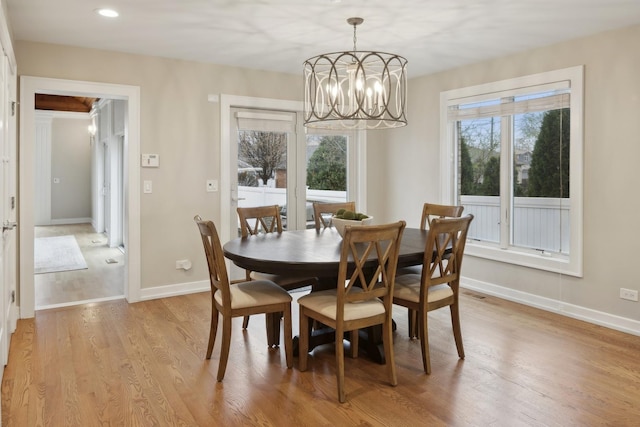 dining space featuring an inviting chandelier and light wood-type flooring