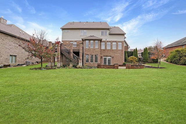 rear view of property featuring a yard and a deck