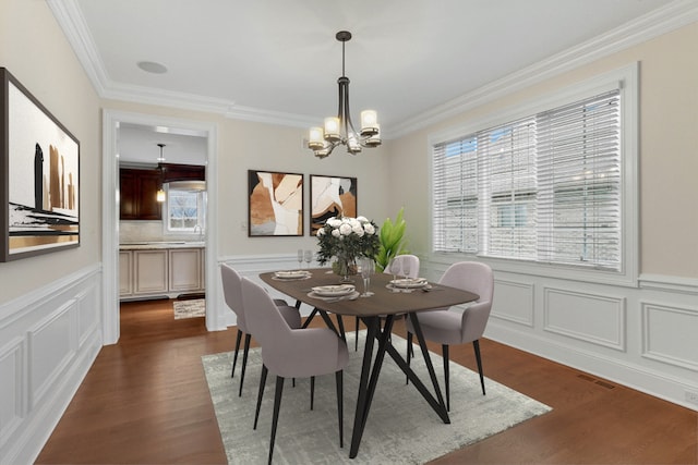 dining space featuring crown molding, dark hardwood / wood-style flooring, and a notable chandelier