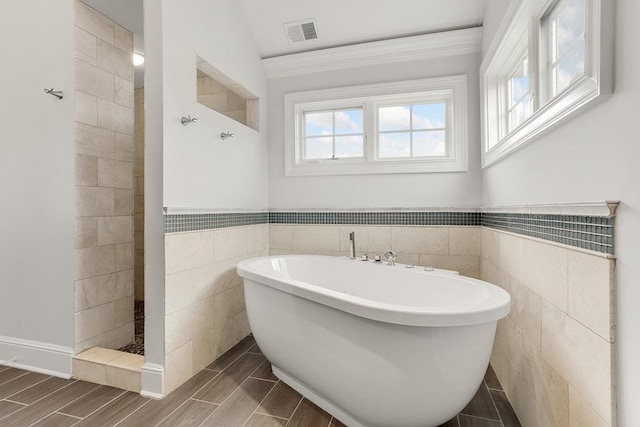 bathroom featuring vaulted ceiling, tile walls, and plus walk in shower