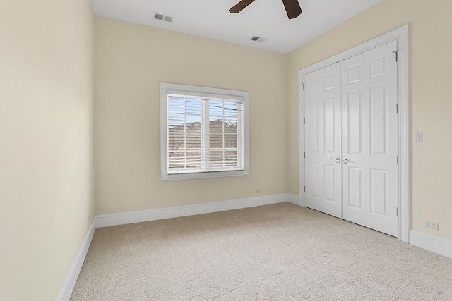 unfurnished bedroom with light carpet, ceiling fan, and a closet