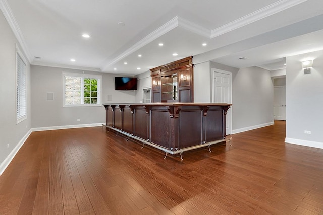 interior space with ornamental molding, dark hardwood / wood-style floors, a breakfast bar area, and kitchen peninsula