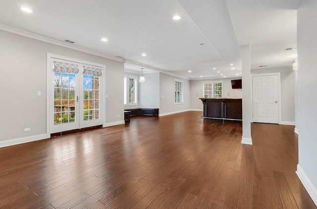 unfurnished living room with ornamental molding and dark hardwood / wood-style flooring